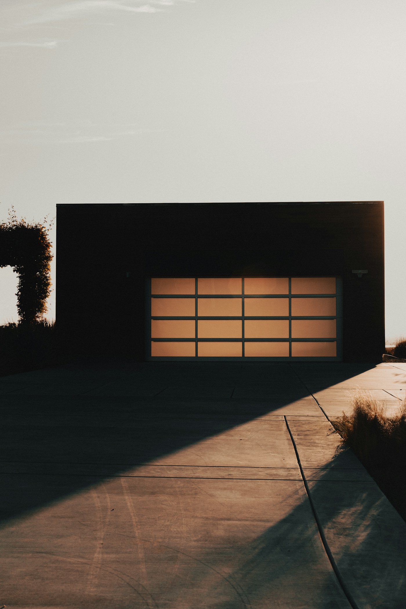 Warm-lit modern garage door at dusk: the kind of stuck or off-track call we answer same day in the East Bay